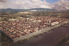 an aerial view of a city with mountains in the background and water running through it