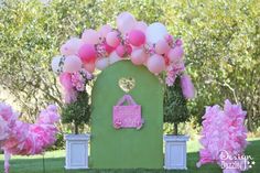 a pink and green gate decorated with balloons