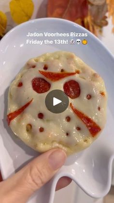 someone is holding a small pizza on a plate