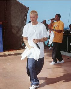 a young man is walking with his skateboard