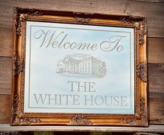 a sign that is on the side of a wooden building saying welcome to the white house