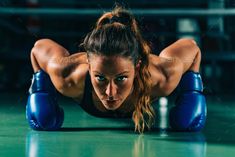 a woman in blue boxing gloves is doing push ups on the floor - stock photo - images