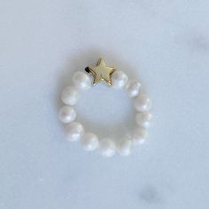 Add a pop of shine to any outfit with a dainty pearl ring with 2.5mm cultured pearls and your choice of star or heart charm. White Jewelry With Star Charm And Round Beads, White Pearl Charm Ring For Promise, White Star-shaped Jewelry With Pearl Charm, Star Charm Ring Jewelry Gift, Adjustable White Pearl Ring With Pearl Charm, Dainty Pearl Ring With Pearl Charm For Gifts, Dainty Pearl Ring With Pearl Charm As Gift, White Pearl Ring With Pearl Charm, Star-shaped Jewelry With Pearl Charm As A Gift