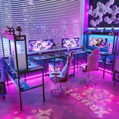 a room with purple lighting and various computer screens on the desks in front of it