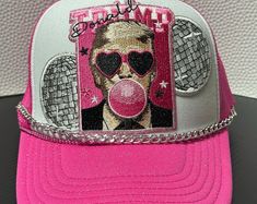 a pink hat with a photo of a man wearing sunglasses and a gas mask on it