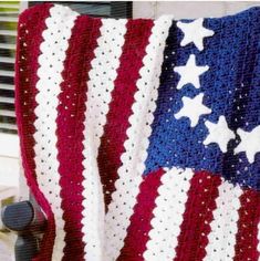 an american flag crocheted afghan draped over a window sill with the colors red, white and blue