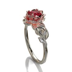 "This amazing engagement ring positively radiates beauty and strength. With its vibrant colors and lovely floral design, it's sure to be a conversation starter. Choose this piece of fine jewelry for someone with a unique spirit. The narrow band is created from gleaming, 14kt white gold, with a symmetrical design of white gold leaves at the top, which surround a beautiful lotus flower crafted from warm rose gold. At the very center sits a glistening, vivid ruby. ★See A Video Of This Amazing Ring Luxury Ruby Flower Ring Fine Jewelry, Luxury Flower-shaped Ruby Ring In Fine Jewelry Style, Red Flower-shaped Ring For Wedding, Red Flower Shaped Wedding Ring, Wedding Red Flower-shaped Ring, Wedding Red Flower Shaped Ring, Red Ruby Flower-shaped Ring, Flower Shaped Ruby Ring As A Gift, Red Ruby Flower Shaped Ring