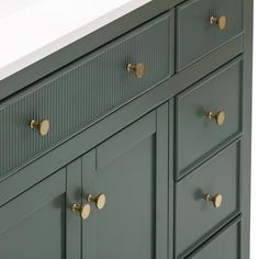 an image of a bathroom vanity with brass knobs on it's doors and drawers