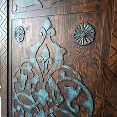 an intricately carved wooden door with blue paint on the front and side paneling