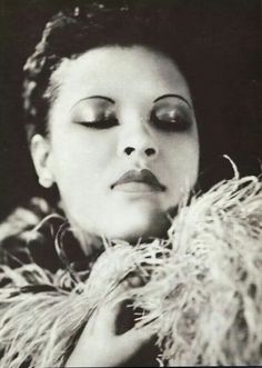 black and white photograph of a woman with her eyes closed, wearing a fur coat