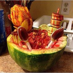 a watermelon filled with different types of food on top of a kitchen counter