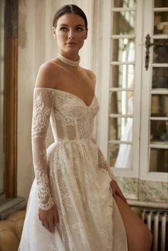 a woman in a wedding dress posing for the camera with her hands on her hips