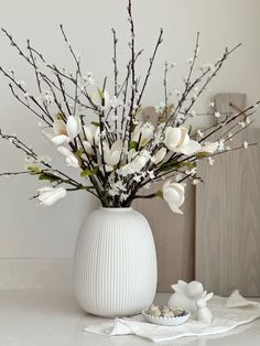 a vase filled with white flowers on top of a table