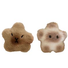 two small stuffed animals sitting next to each other on a white surface, one is brown and the other is beige