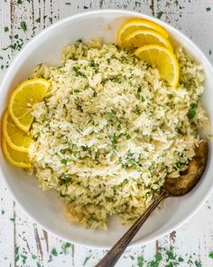 a white bowl filled with rice and lemons