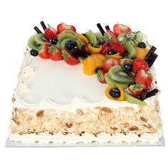 a white cake topped with lots of fruit on top of coconut flakes and nuts