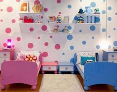 two children's beds in a room with polka dots on the wall