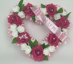 a heart shaped wreath with pink and white flowers in the shape of a mum sign