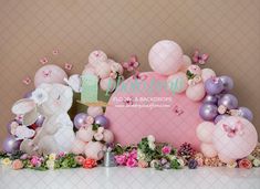 a table topped with balloons and bunnies filled with flowers