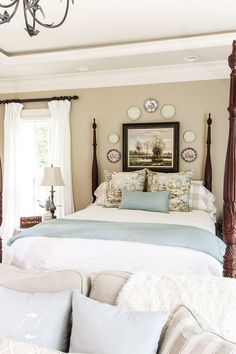 a bedroom with four poster bed and white walls