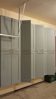 several gray cabinets in a room with red walls and metal bars hanging from the ceiling