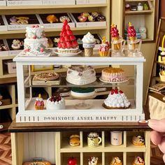 a miniature display case filled with cakes and cupcakes