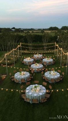 an aerial view of a table set up for a formal dinner in the middle of a field