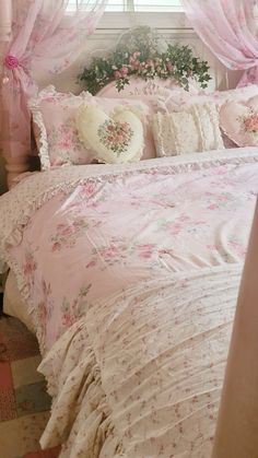 a bed with pink comforters and pillows in a room