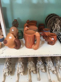 pottery is displayed on a shelf in a shop