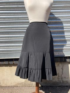 "This is an unusual piece and it is in excellent vintage condition. It is made of a gently padded nylon/polyester fabric which gives the skirt a lovely fit and shape.  It has a narrow waistband and an invisible side zip with a hook and eye.  It has four darts into the waistband and is gently flared with a pretty tiered hem.   Corinne Cobson is a French Fashion Designer famous for her Rock and Roll inspired edge...she died in 2019. Waist 28\" Hips 40\" Length from waist to hem 27\"" Black Tiered Skirt, Rock And, Fashion Designers Famous, French Fashion Designers, The 1980s, Tier Skirt, Tiered Skirt, French Fashion, Fashion Designer