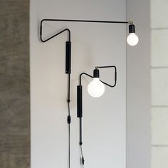 two lamps are hanging on the wall next to each other, one light is turned on