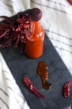 hot sauce and chili peppers on a slate board