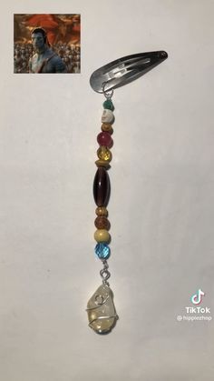 a key chain with beads and charms hanging from it's side on a white background