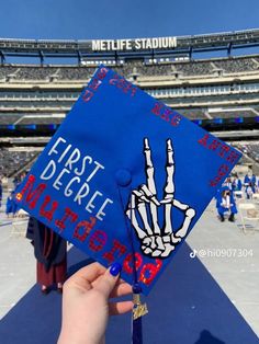 someone is holding up their graduation cap at the stadium