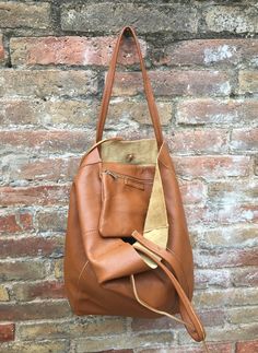 Large tote leather bag in dark CAMEL BROWN. Saddle brown shoulder bag. Tan color natural GENUINE leather. Large enough for books or a laptop, tablet, cosmetics bag etc. Leather shopper. The inside of the bag is not lined (although properly finished!) . We added a small leather pouch on the inner part of the bag (4th pic) The bag can be closed by 2 leather straps attached to each side. Excellent quality soft but strong genuine leather. Width upper part: 41cm - 16 inch Height: 38 cm - 15 inch This Small Leather Pouch, Tote Leather Bag, Saddle Brown, Cosmetics Bag, Brown Shoulder Bag, Brown Bag, Brown Bags, Leather Pouch, Large Tote