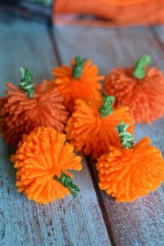 small orange pom poms sitting on top of a wooden table