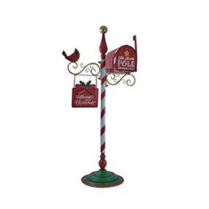 a red and white pole with a christmas sign on it's side next to a bird