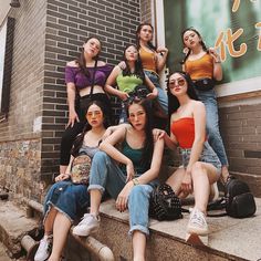 a group of young women sitting on steps next to each other