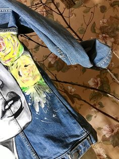 a denim jacket with flowers painted on it