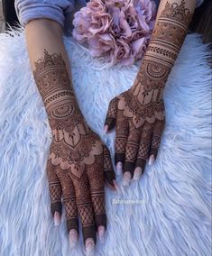 a woman's hands with hennap and flowers on top of her hand