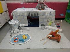 a room filled with toys and decorations on the floor in front of a bed made out of ice