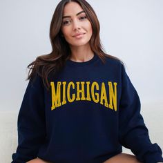 Score major style points with our Michigan Sweatshirt! This spirited design is your ticket to Pure Michigan vibes and college football fervor. Crafted for comfort and Midwestern pride, this sweatshirt lets you wrap yourself in warmth and gridiron spirit - where comfort meets game day excitement! Ideal for any situation, a unisex heavy blend crewneck sweatshirt is pure comfort. These garments are made from polyester and cotton. This combination helps designs come out looking fresh and beautiful. The collar is ribbed knit, so it retains its shape even after washing. There are no itchy side seams on these sweaters.  .: Made with a medium-heavy fabric blend of 50% cotton and 50% polyester (8.0 oz/yd² (271.25 g/m this sweatshirt feels cozy and is the perfect choice for those colder months. .: T Varsity Sweatshirt With University Logo For Game Day, Collegiate Sweatshirt With University Logo For Game Day, Oversized Fan Apparel Sweatshirt For College, Oversized Collegiate Sweatshirt For College, Oversized College Sweatshirt For Fan Apparel, Varsity Style Fan Merchandise Tops For Fall, Oversized School Spirit Sweatshirt For Campus, Collegiate Campus Sweatshirt With Text Print, Collegiate Sweatshirt With Text Print For Campus