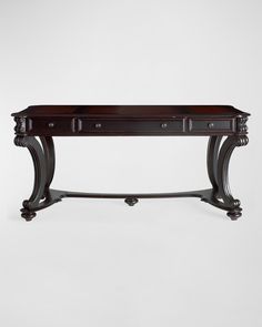 an ornate console table with drawers on one end