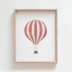 a red and white striped hot air balloon in a wooden frame on the wall above a toilet