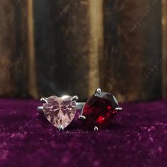 two heart shaped gems are sitting on purple carpet