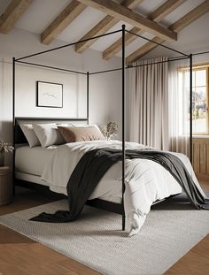 a bedroom with a four post bed and wooden beams on the ceiling, along with a large window