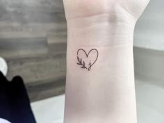 a small heart tattoo on the wrist