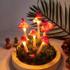 a group of mushrooms sitting on top of a wooden bowl filled with moss and lit candles