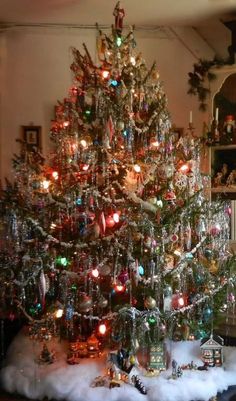 a small christmas tree with lights and ornaments