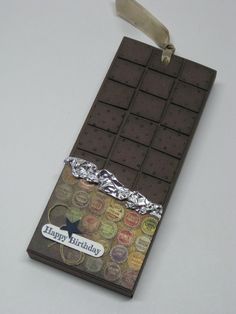 a chocolate bar is decorated with foil and ribbon